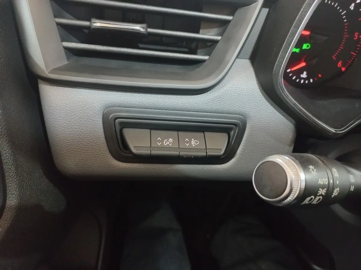 Détail intérieur du tableau de bord côté gauche de la Renault Clio blanche 2020, avec commandes de réglage des phares.