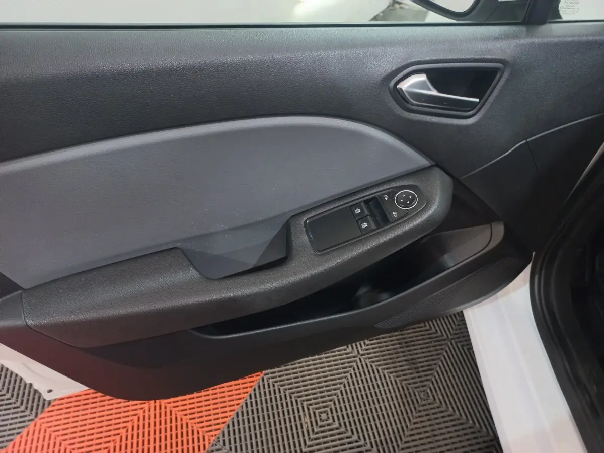 Vue rapprochée de la porte avant gauche blanche d'une Renault Clio 2020 avec commandes électriques des vitres.