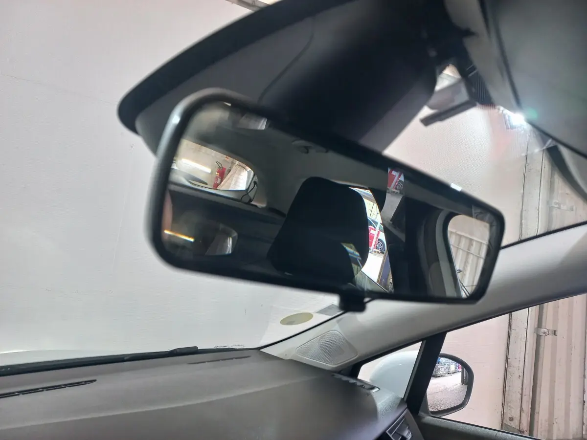 Vue intérieure du rétroviseur central d'une Renault Clio blanche 2020, avec siège arrière visible en reflet.