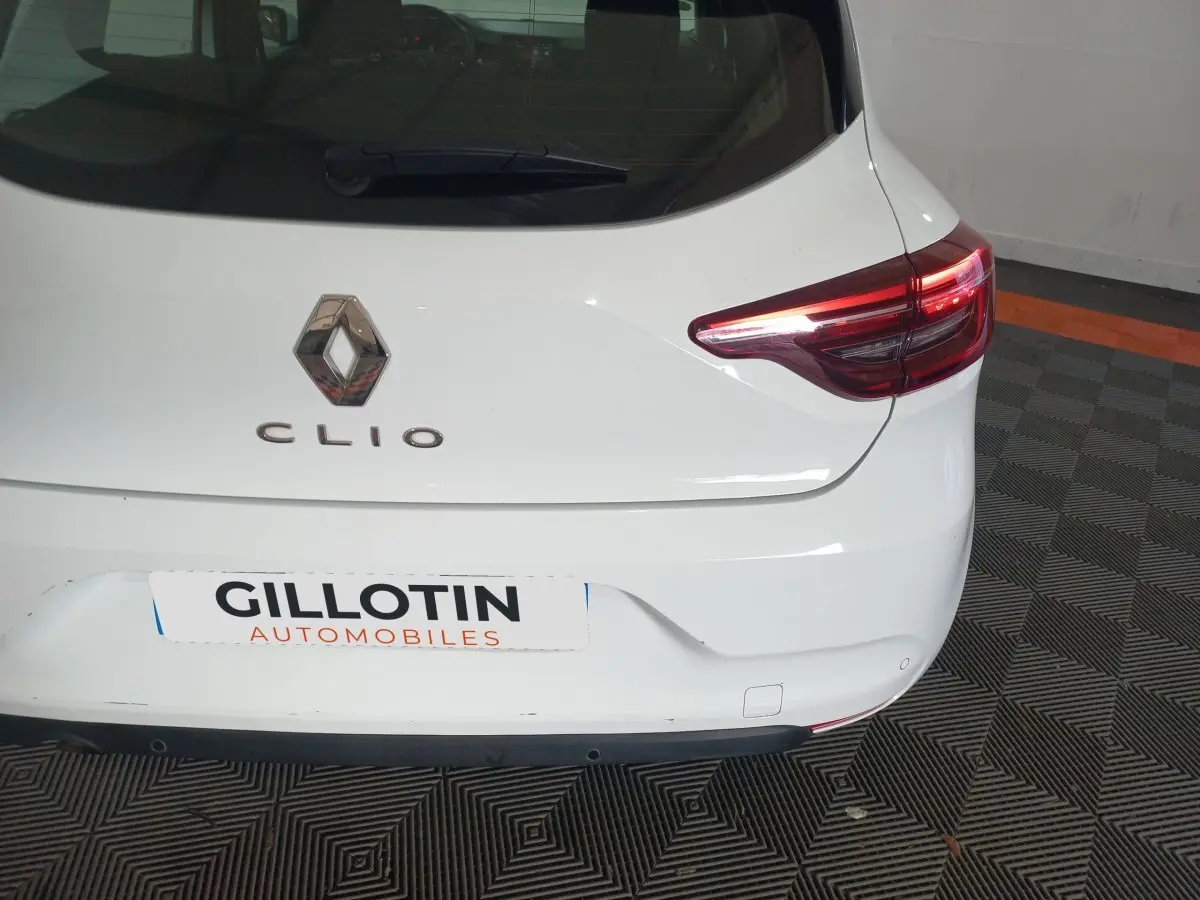 Vue arrière droite d'une Renault Clio blanche de 2020 avec feux arrière LED et logo Renault visible.