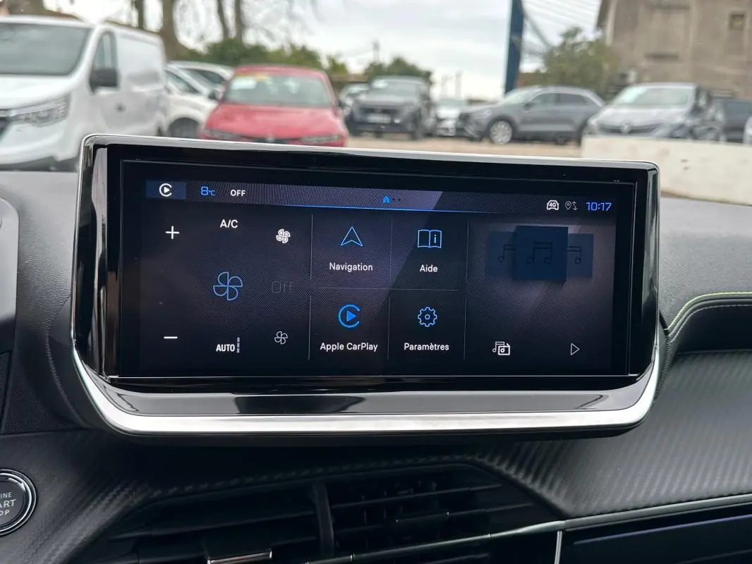 Vue intérieure centrée sur l'écran tactile du tableau de bord de la Peugeot 208 gris, affichant les options de navigation et climatisation.
