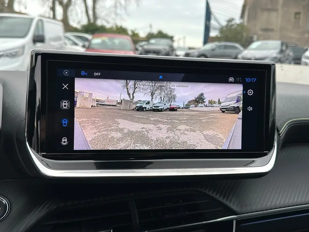 Écran tactile intérieur montrant la caméra de recul du Peugeot 208 gris, vue du tableau de bord.