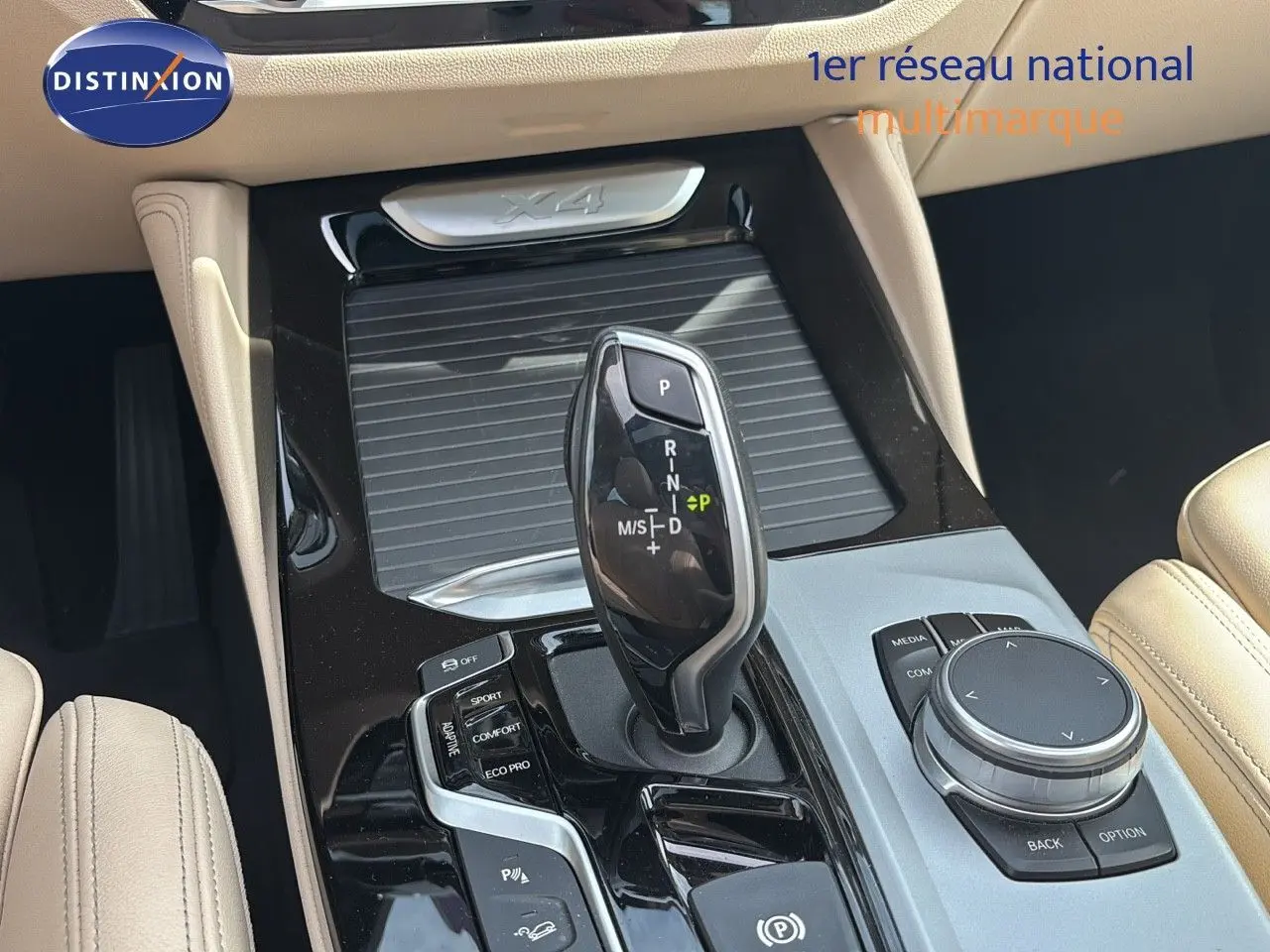 Gros plan sur la console centrale beige d’un BMW X4 XDRIVE 30D 2019, mettant en valeur le levier de vitesse automatique.