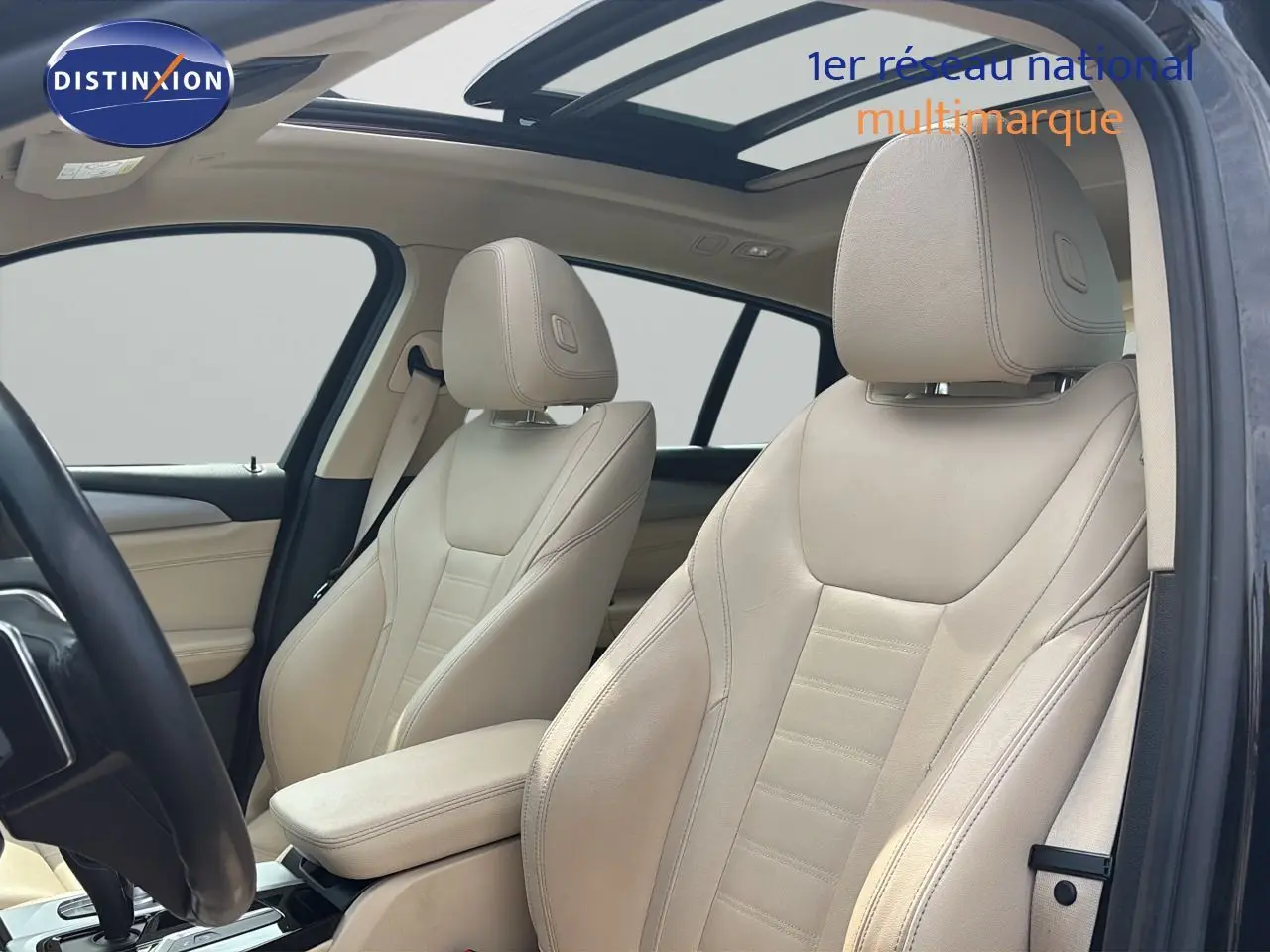 Intérieur beige cuir du BMW X4 XDRIVE 30D 2019 vu côté conducteur avec toit panoramique et volant noir.