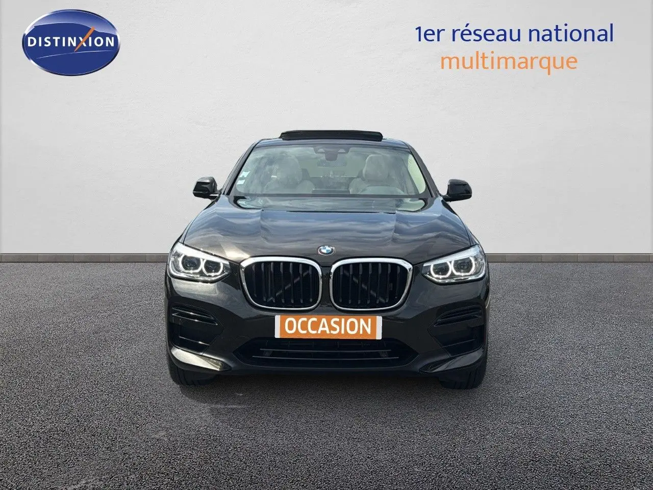 Vue frontale d'un BMW X4 XDRIVE 30D Sparkling Storm Métal avec phares LED allumés sur fond neutre.