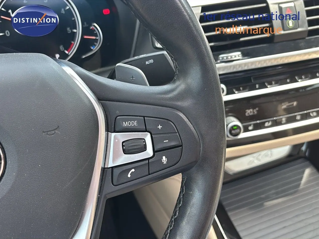 Gros plan sur le volant cuir noir et la console centrale du BMW X4 XDRIVE 30D Sparkling Storm Métal de 2019.