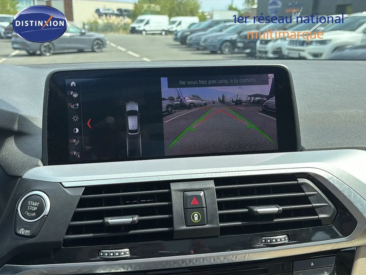 Écran central du BMW X4 30D 2019 montrant la caméra de recul avec les lignes de guidage vertes et rouges.