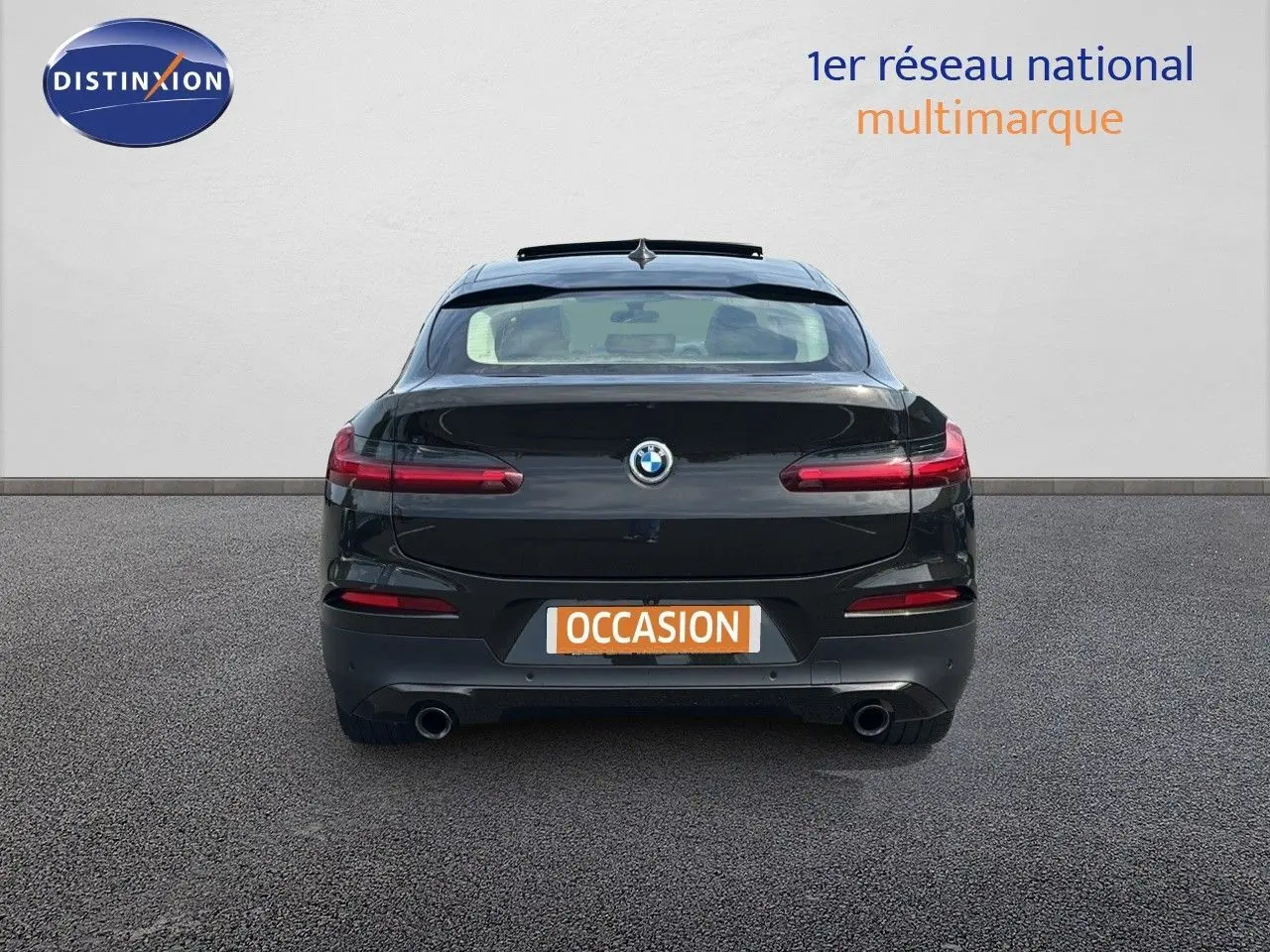 Vue arrière d'un BMW X4 XDRIVE 30D Sparkling Storm Métal avec feux LED et double sortie d'échappement visible.