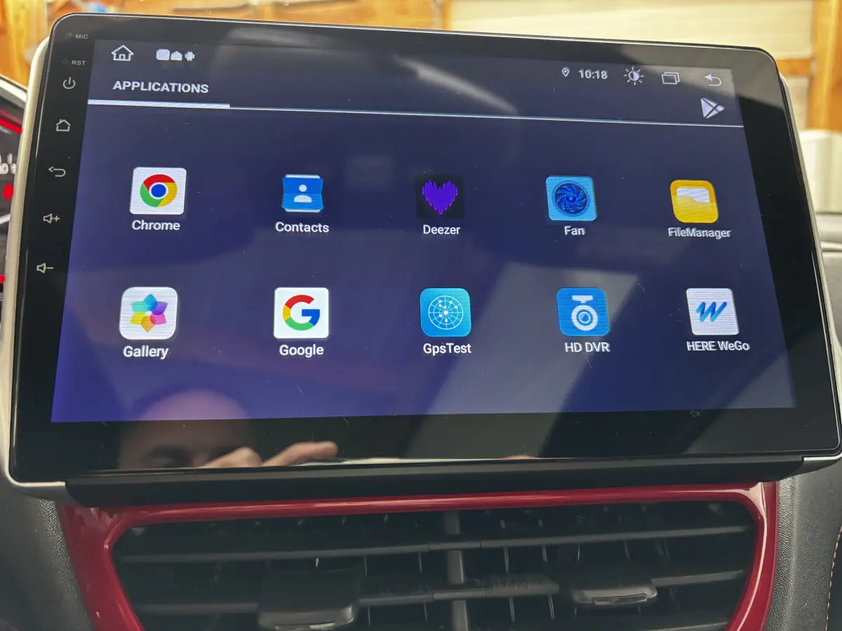 Écran tactile central de la Peugeot 208 GTI 2013 affichant des applications multimédias avec cadre rouge autour de la console.