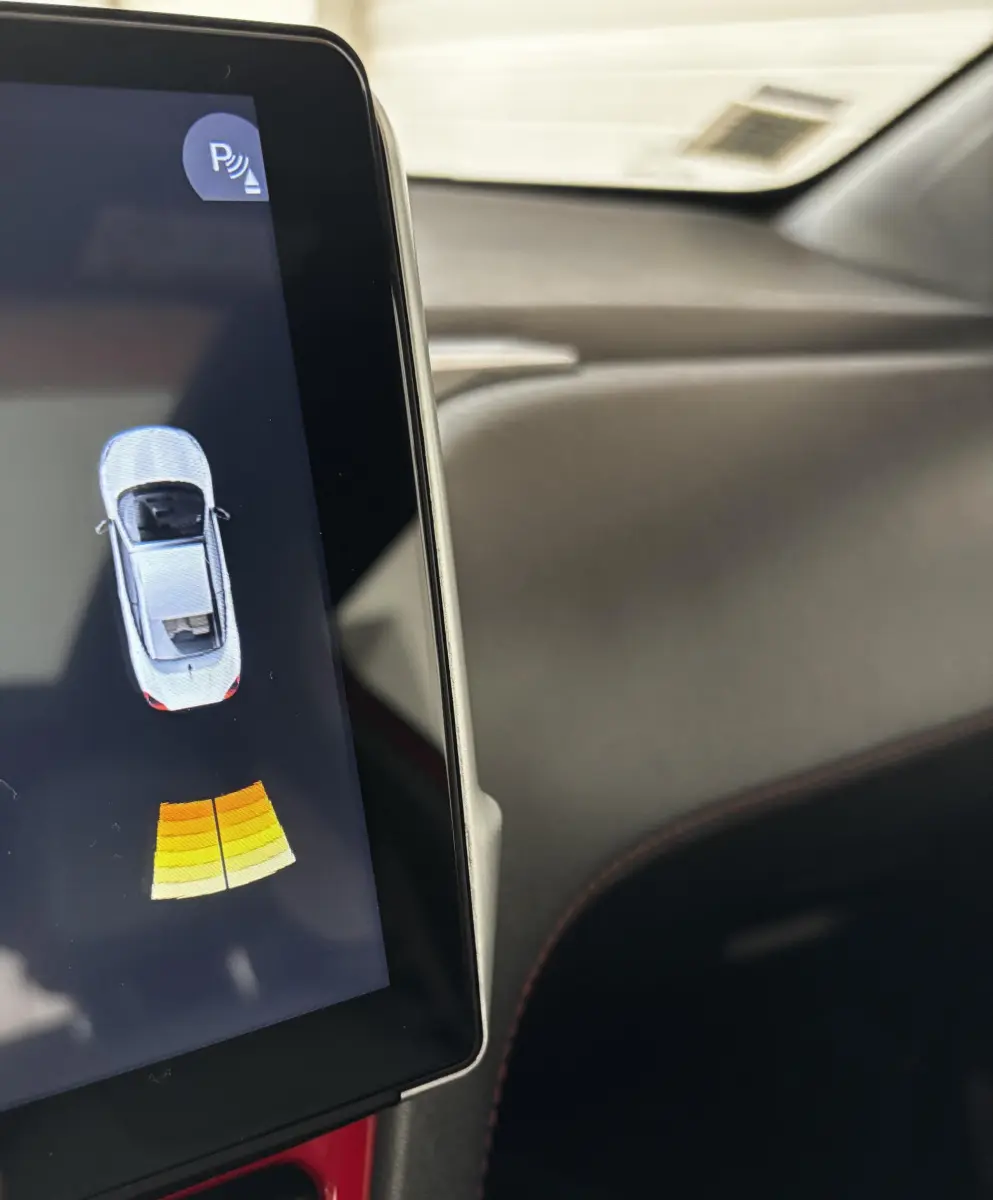 Affichage du capteur de distance au stationnement sur l'écran tactile intérieur d'une Peugeot 208 GTI rouge.