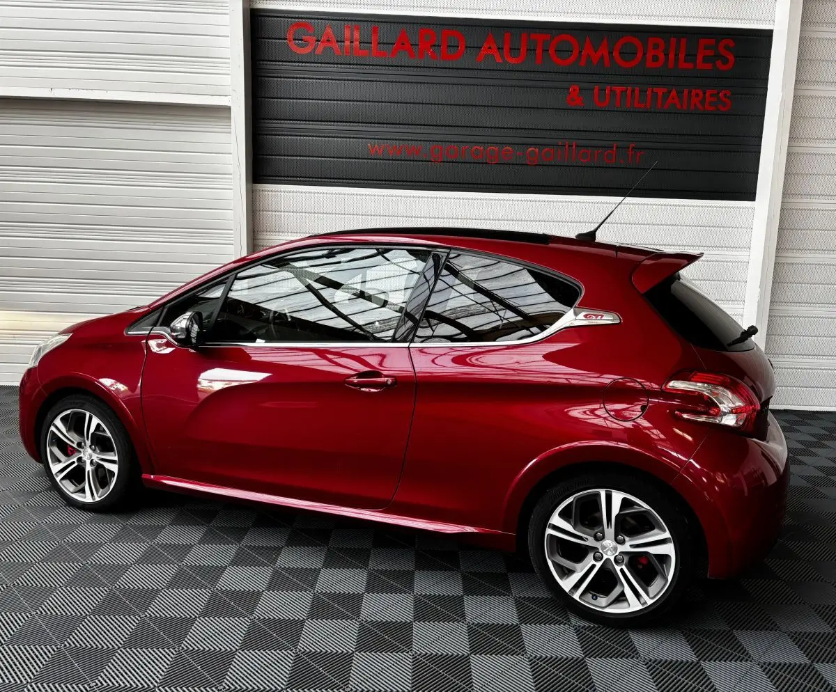 Profil droit d'une Peugeot 208 GTI rouge 2013 avec toit panoramique et jantes alliage sport.