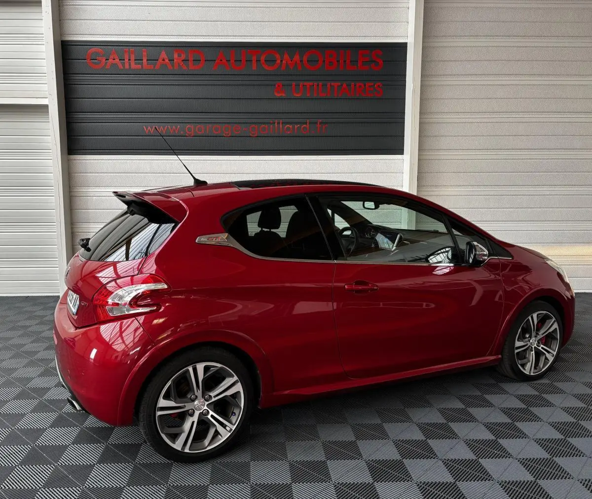 Peugeot 208 1.6 THP 200 GTI rouge vue de profil côté gauche avec toit panoramique et jantes alliage sport.