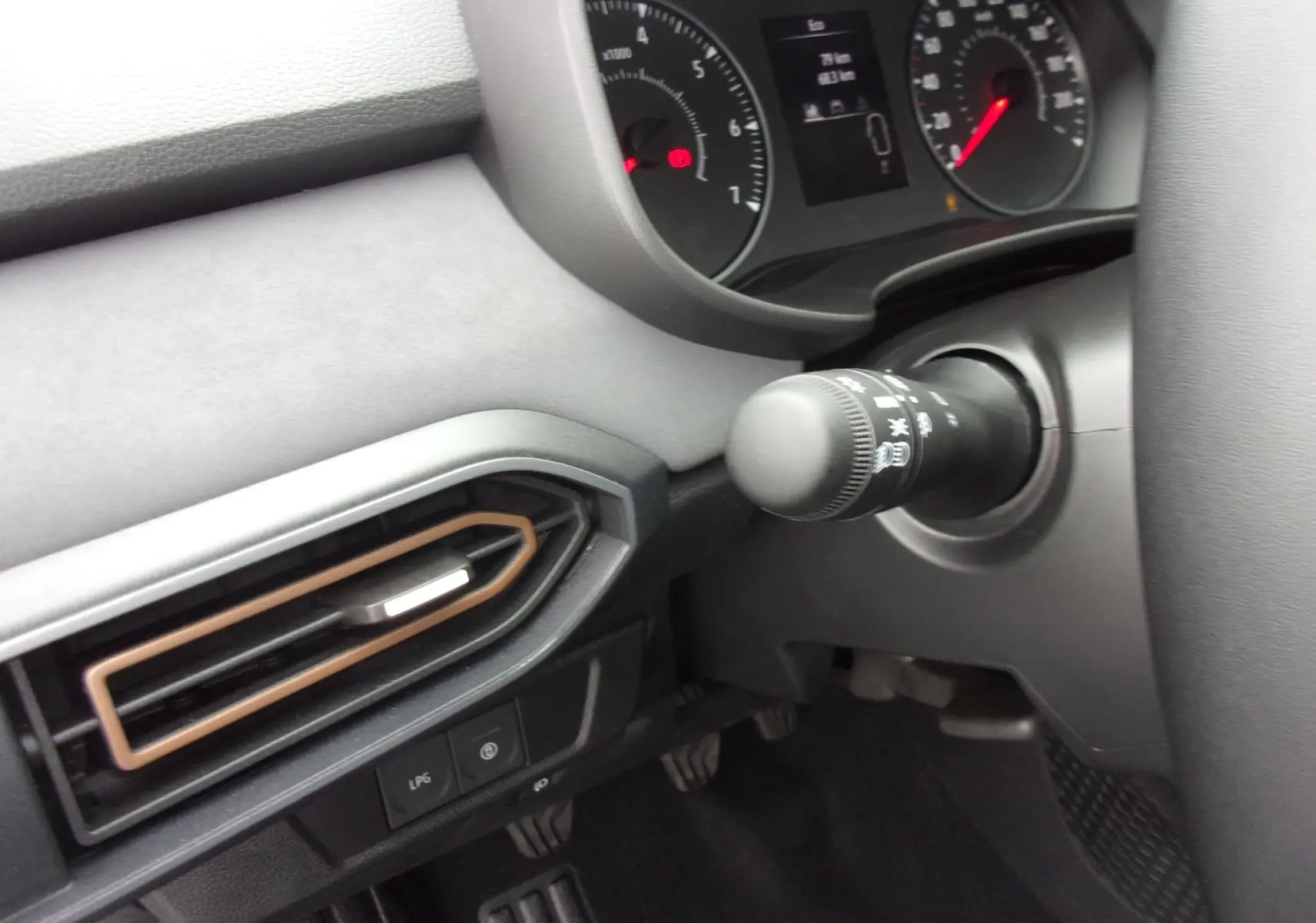 Détail du tableau de bord côté gauche du Dacia Jogger blanc 2025, avec commandes et aérateurs noirs et bronze.