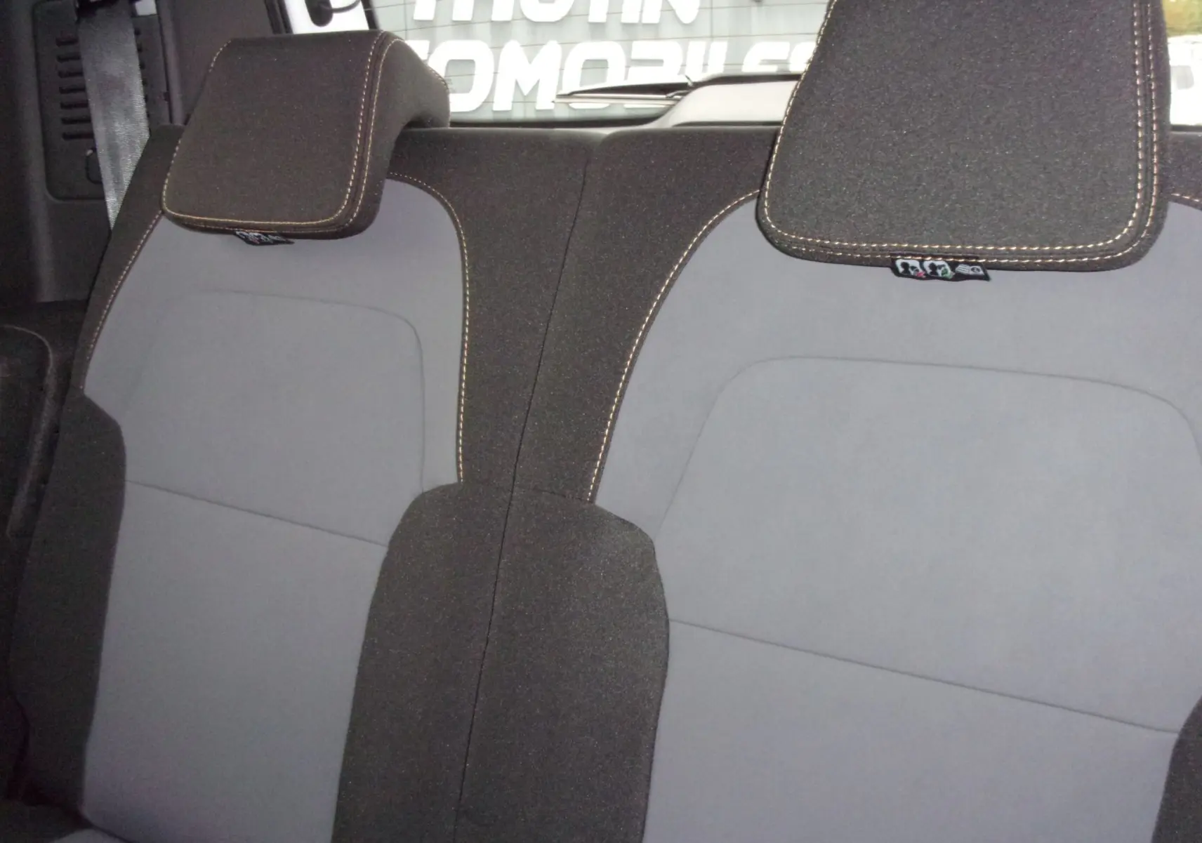 Détail des sièges arrière gris et noirs du Dacia Jogger blanc 2025, version ECO-G 100 7 places.