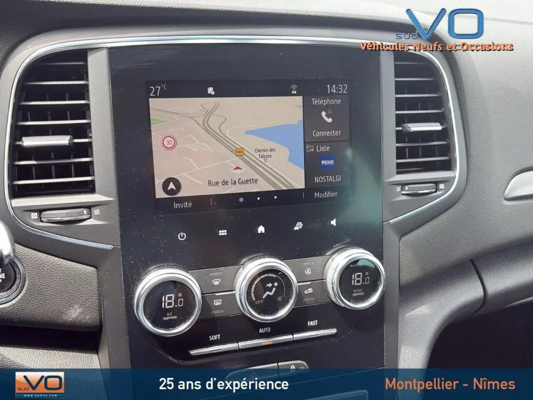 Vue rapprochée du tableau de bord de la Renault Mégane IV gris foncé, avec écran tactile et commandes de climatisation.