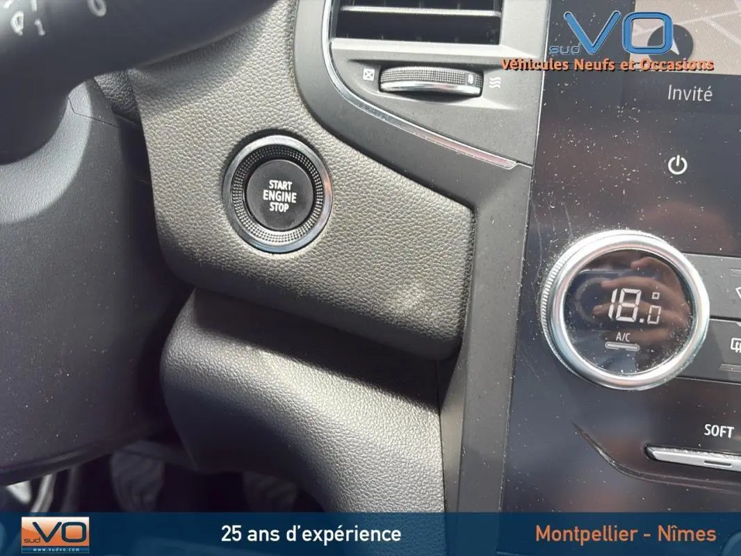 Bouton Start Engine Stop sur tableau de bord noir de Renault Megane IV Berline gris foncé, détail intérieur côté conducteur.