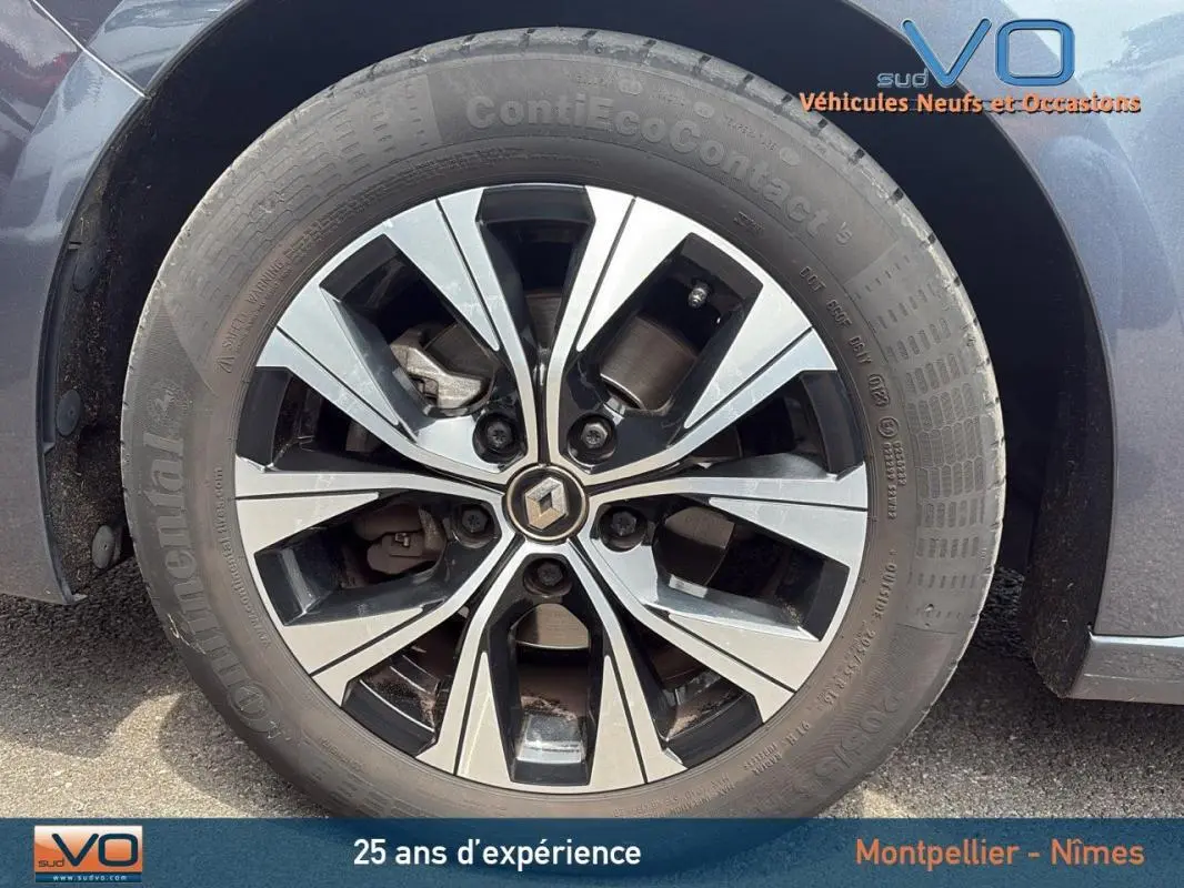 Gros plan sur la jante alliage 16 pouces d'une Renault Mégane IV gris foncé, avec logo Renault au centre.