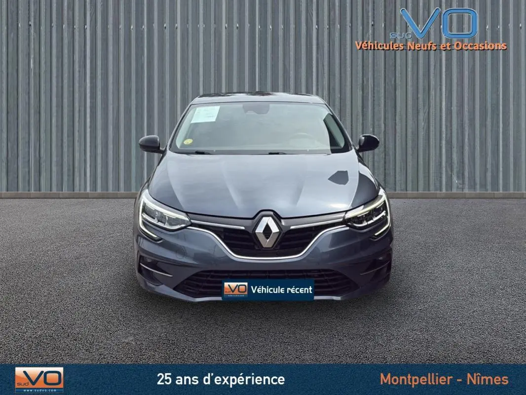 Vue frontale d'une Renault Mégane IV Berline gris foncé avec phares LED et calandre chromée visible sur fond neutre.