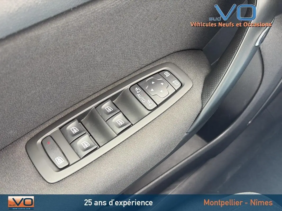 Commande des vitres électriques côté conducteur de la Renault Mégane IV Berline gris foncé, avec réglage des rétroviseurs électriques.