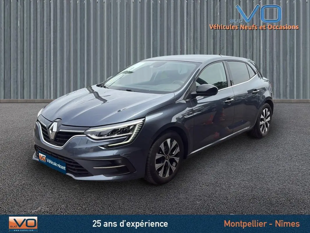 Renault Mégane IV Berline gris foncé vue 3/4 avant droit, avec jantes alliage et phares LED caractéristiques.