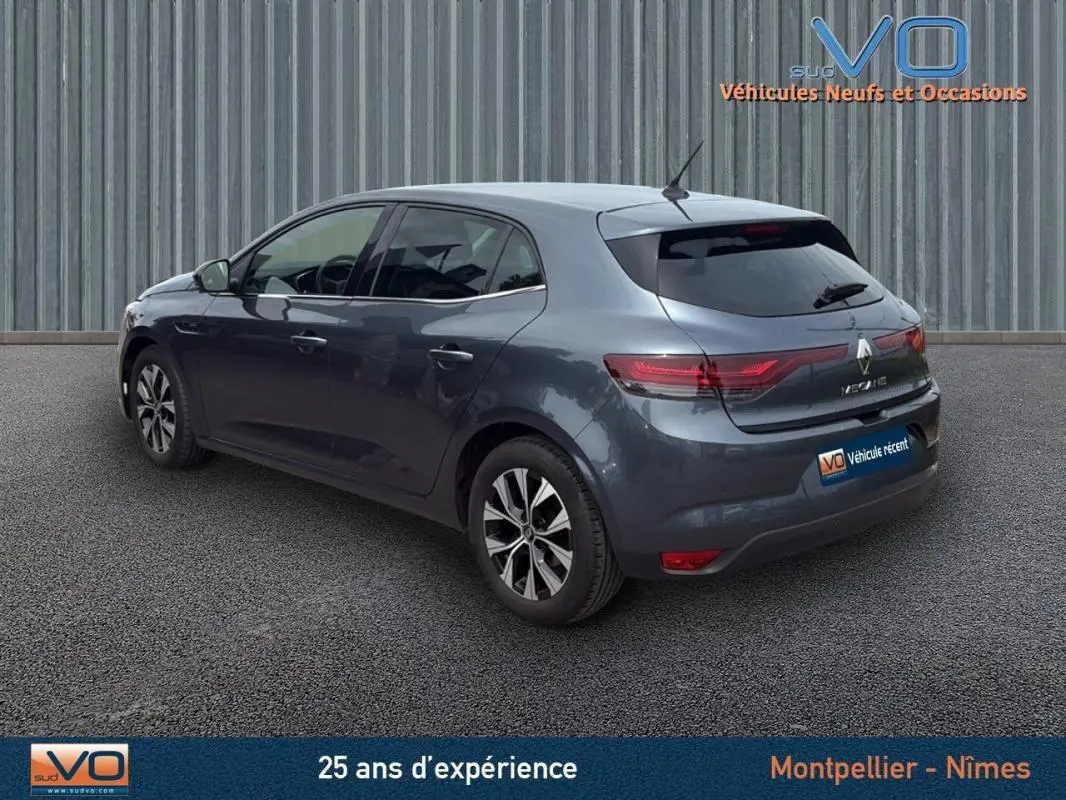 Renault Mégane IV Berline gris foncé vue 3/4 arrière droit, jantes alliage 16 pouces et feux arrière LED visibles.