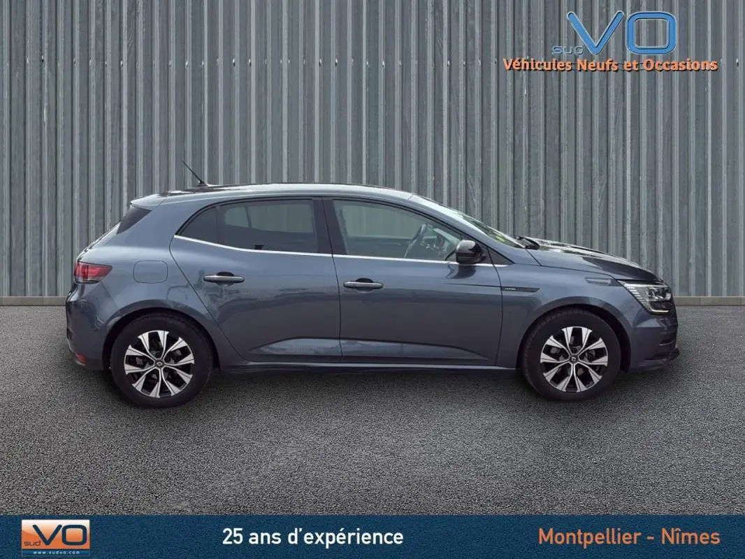 Profil côté droit de la Renault Mégane IV gris foncé avec jantes alliage et rétroviseurs électriques rabattables.