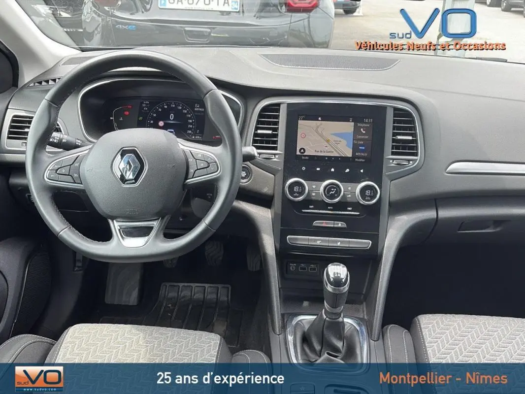 Intérieur de la Renault Mégane IV Berline gris foncé, vue frontale du tableau de bord avec volant et écran tactile central.