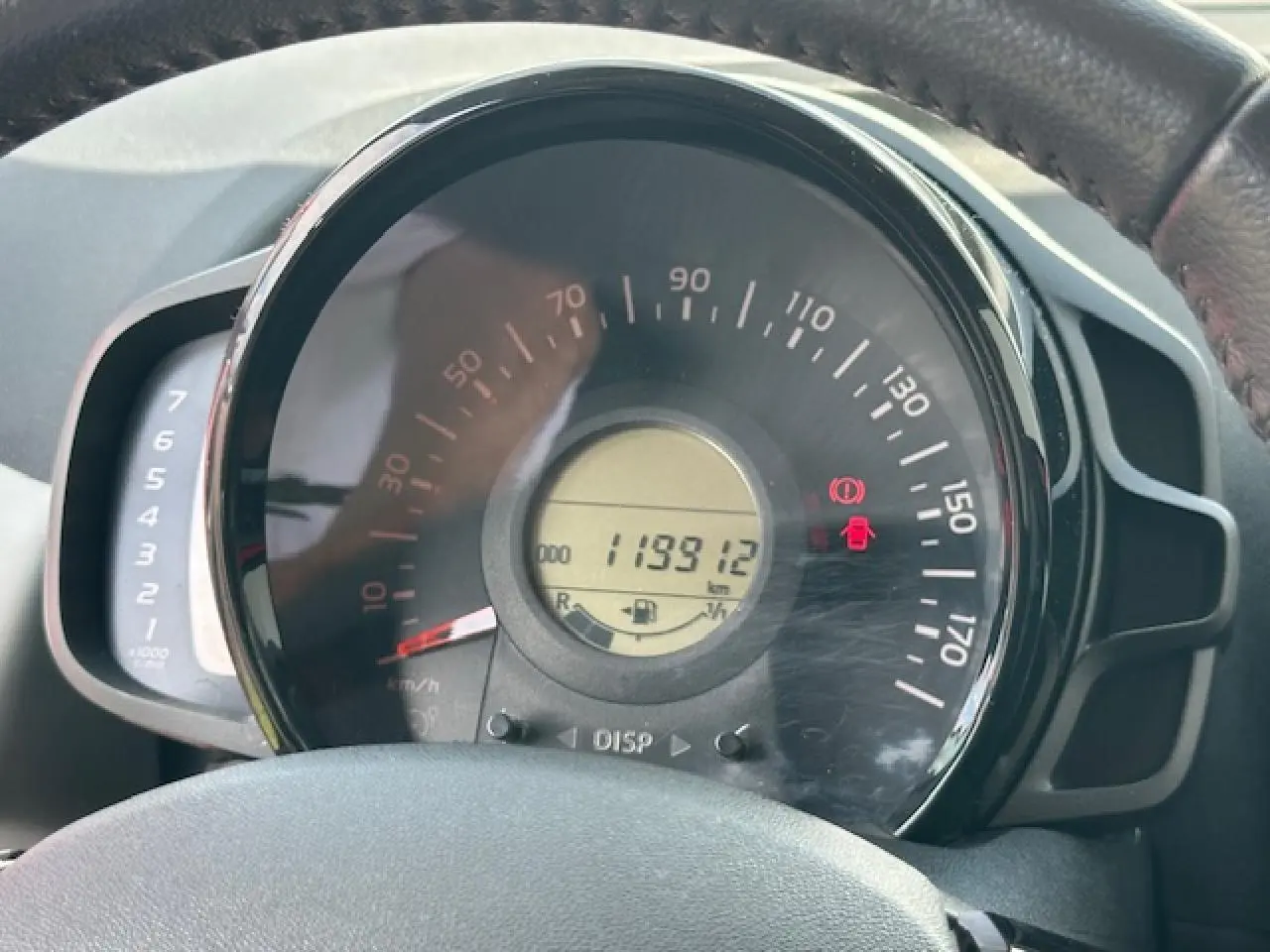 Gros plan sur le compteur de vitesse et compte-tours du tableau de bord de la Citroën C1 rouge Scarlet de 2014.