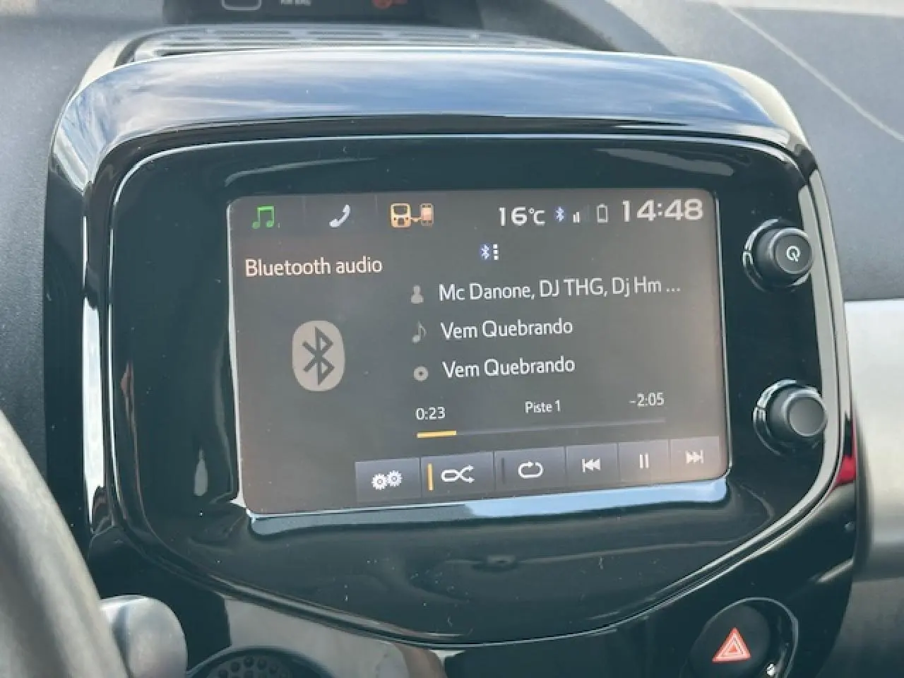 Écran tactile central de la Citroën C1 Rouge Scarlet 2014 affichant la musique Bluetooth en cours de lecture.