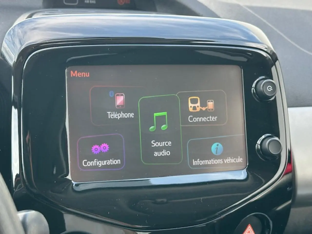Écran tactile central de la Citroën C1 rouge Scarlet de 2014 affichant le menu multimédia avec options connectivité et audio.