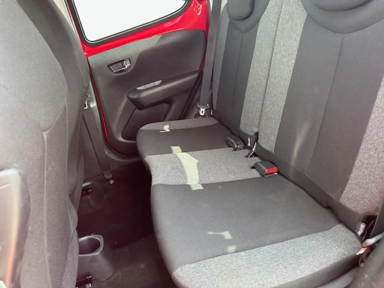 Banquette arrière bicolore gris et noir de la Citroën C1 rouge Scarlet, vue côté droit avec porte ouverte.