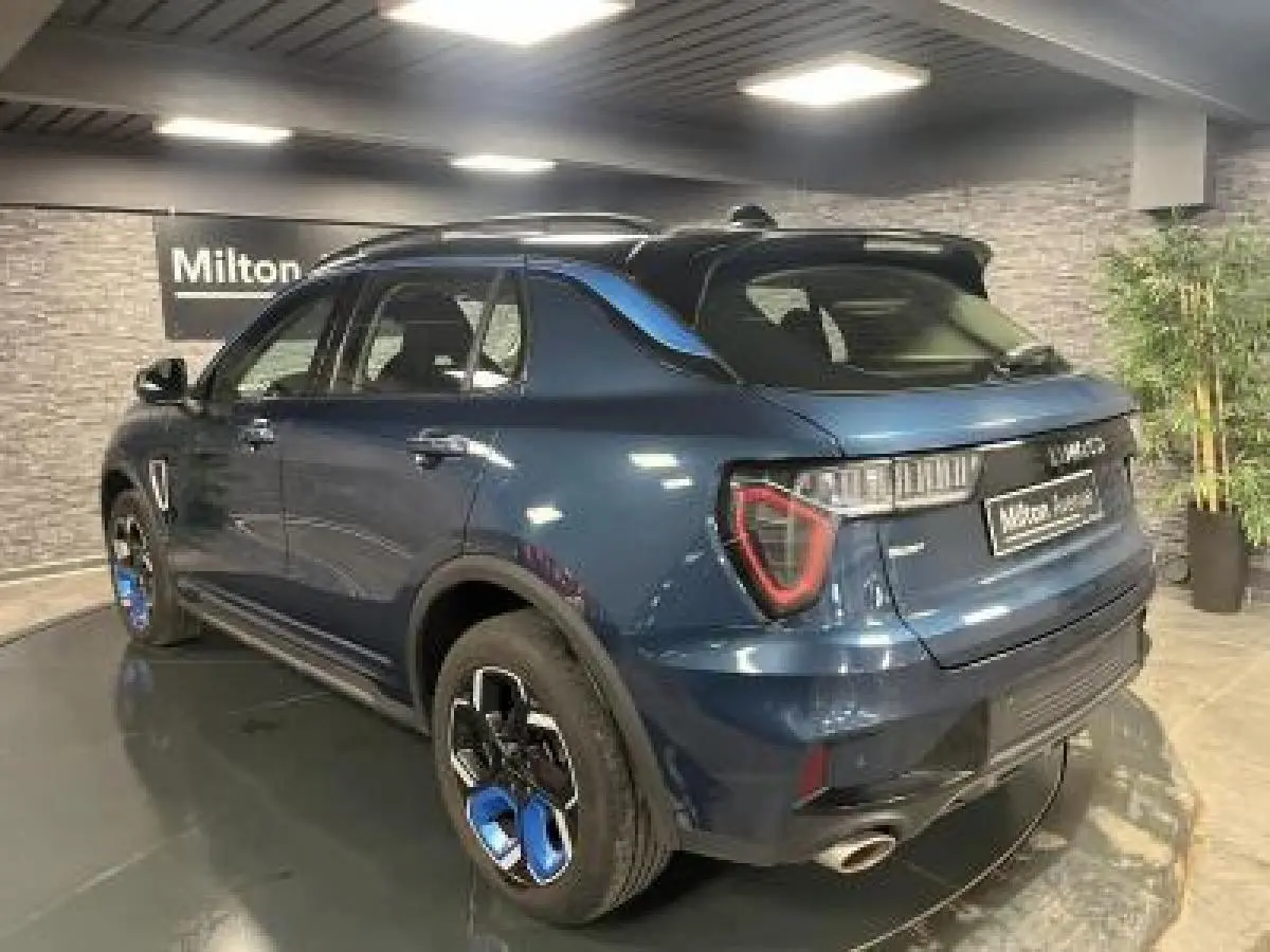 Lynk & Co 01 bleu métallisé vu en 3/4 arrière droit avec jantes bicolores et feux LED distinctifs.