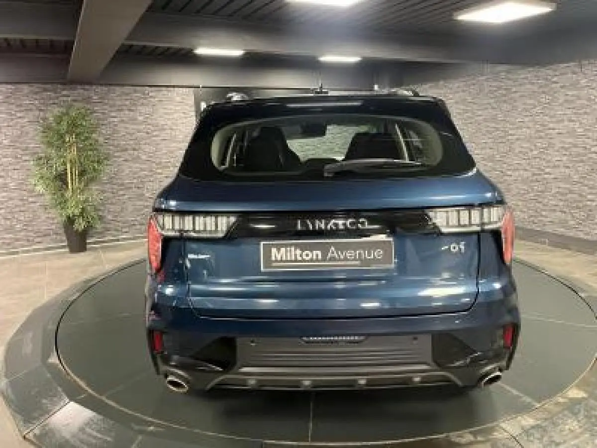 Vue arrière d'un SUV LYNK & CO 01 bleu métallisé avec double sortie d'échappement et feux arrière LED.