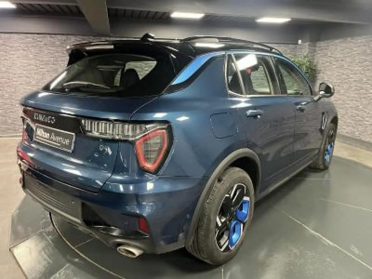 Vue 3/4 arrière droite du SUV Lynk & Co 01 bleu avec jantes bicolores et feux arrière LED distinctifs.