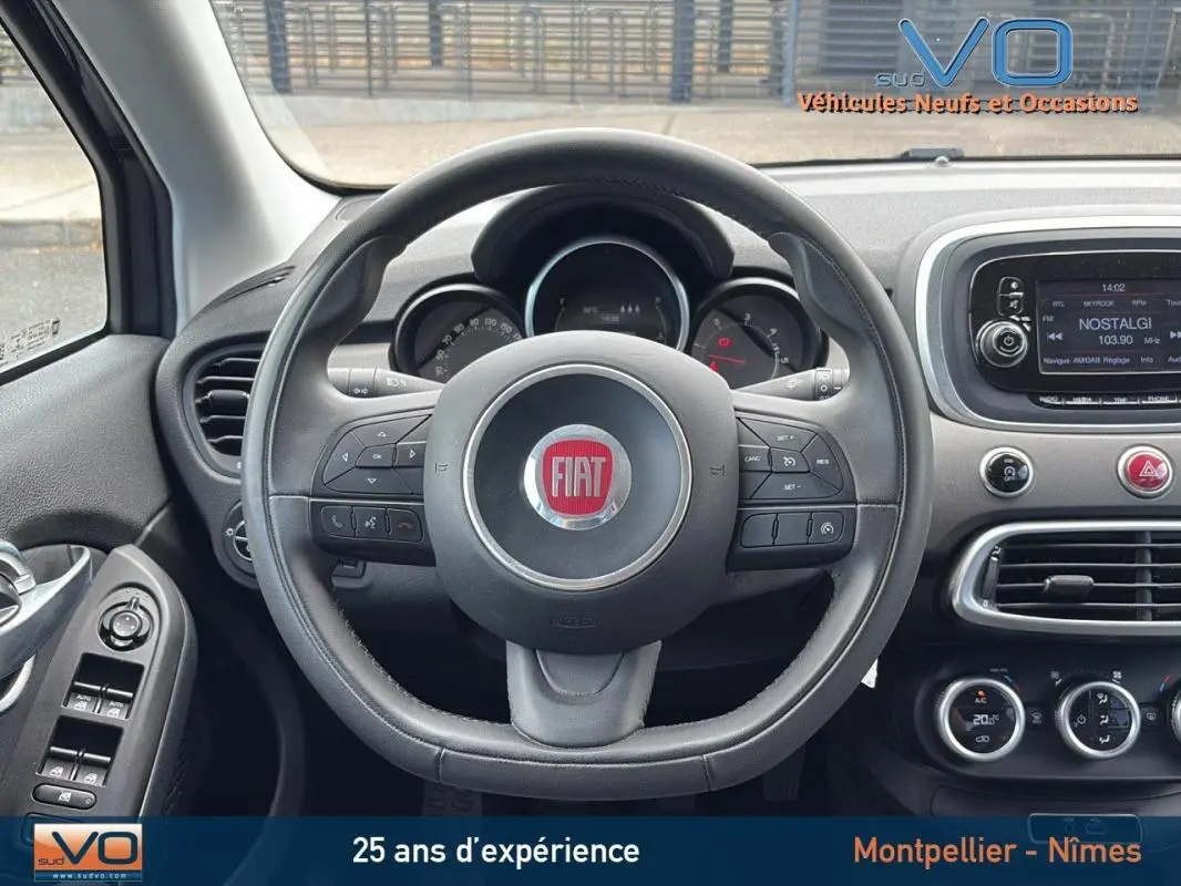 Vue centrée sur le volant cuir de la Fiat 500X gris anthracite avec tableau de bord et écran tactile visibles.