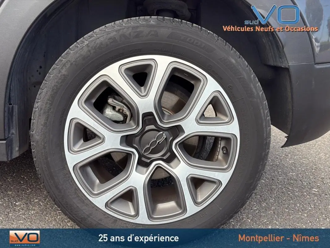 Gros plan sur la jante alliage 17 pouces et le pneu d'un FIAT 500X gris anthracite côté avant droit.