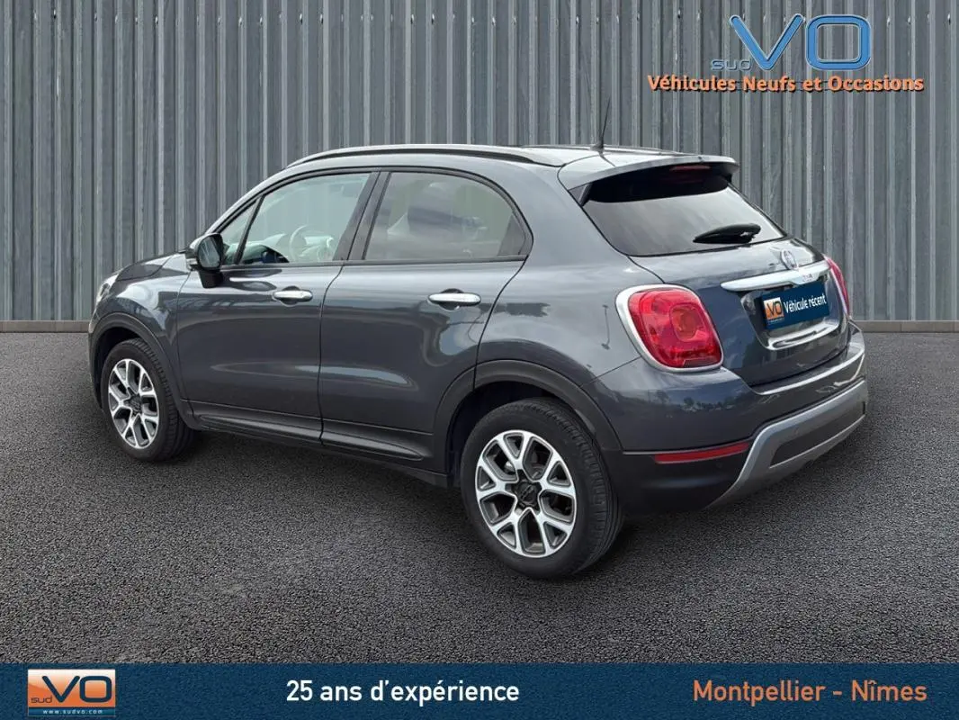 FIAT 500X gris anthracite vue 3/4 arrière côté gauche, jantes alliage 17 pouces et vitres teintées.