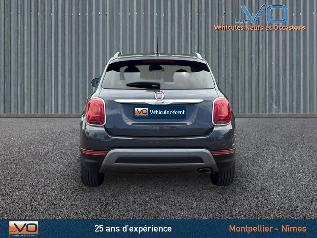 Vue arrière d'une FIAT 500X Cross gris anthracite avec feux arrière rouges et jantes alliage 17 pouces visibles.