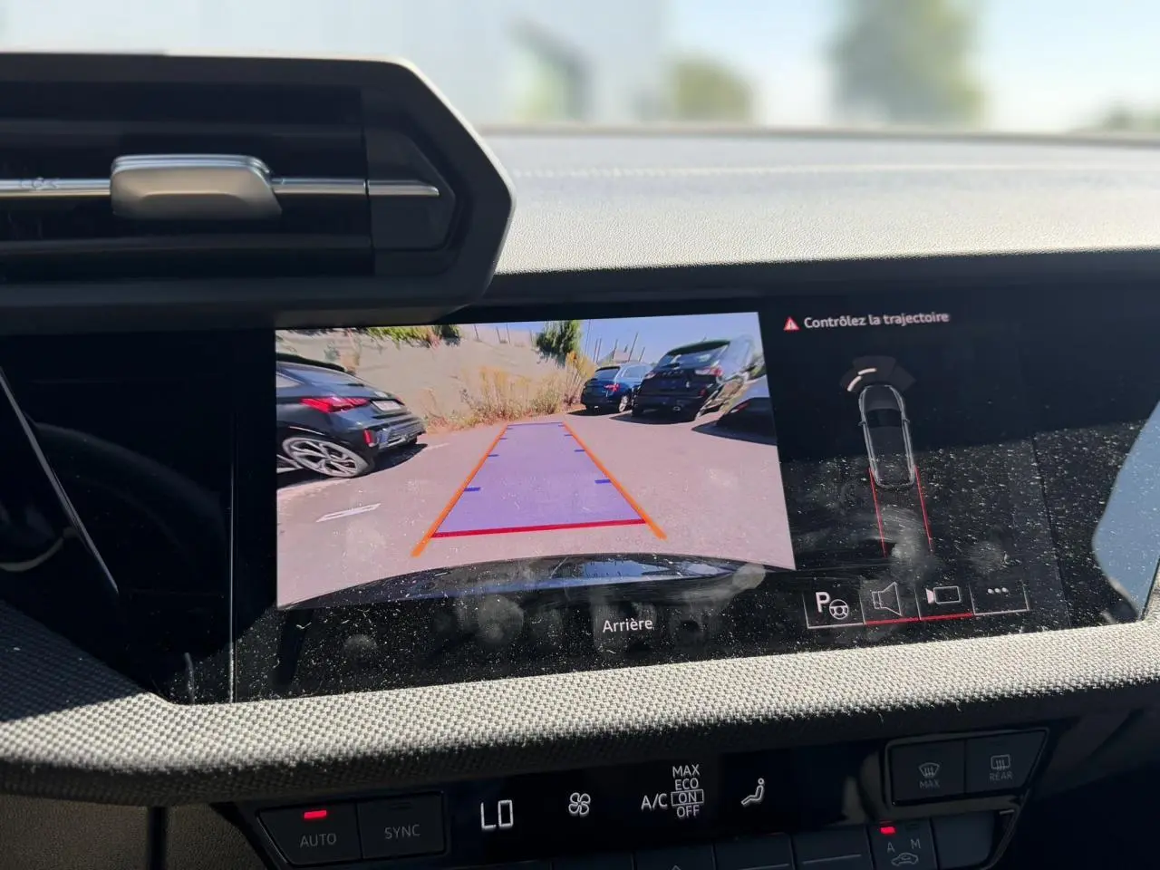 Écran central montrant la caméra de recul avec guidage de trajectoire dans un Audi A3 Sportback noir Mythe, vue intérieure.