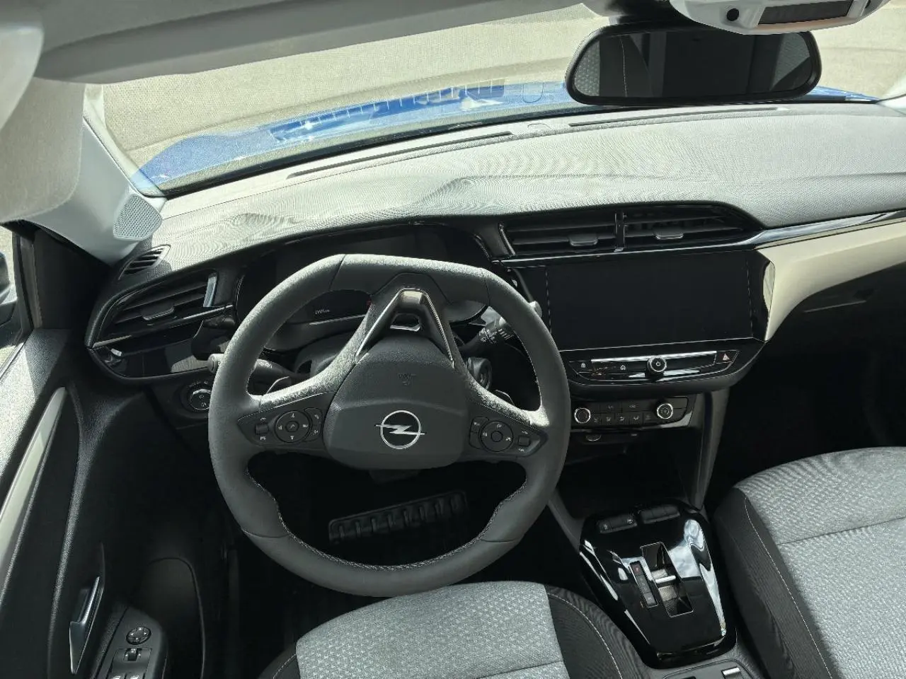Vue intérieure de face de l’Opel Corsa 2025 gris kristall, montrant le volant multifonction et l’écran tactile central.