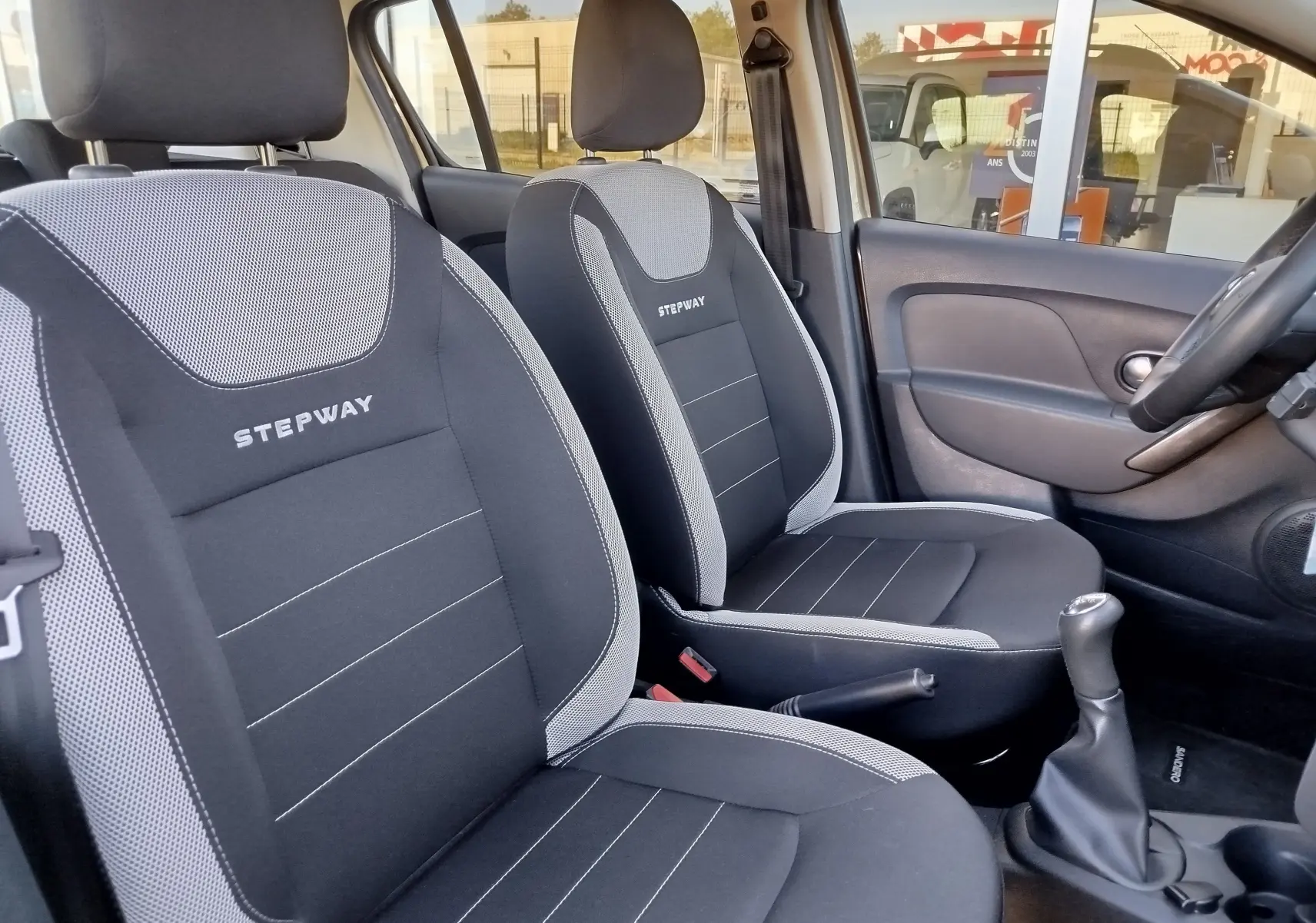 Intérieur de la Dacia Sandero Stepway 2020, vue côté conducteur sur sièges tissu gris avec logo Stepway brodé.