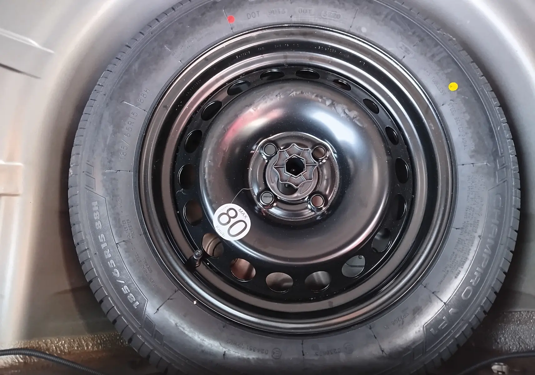 Gros plan sur la roue de secours noire avec étiquette 80 km/h du Dacia Sandero Stepway beige dune 2020