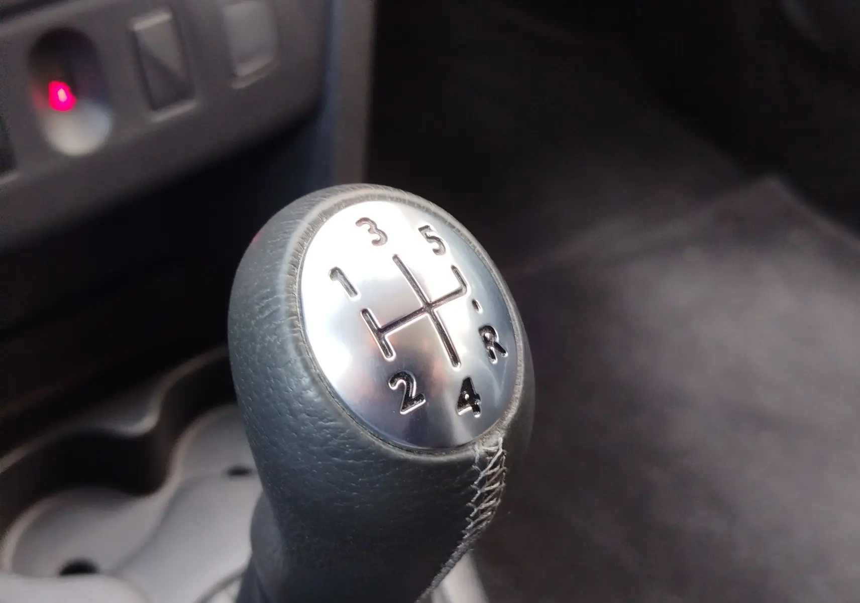 Le levier de vitesse manuel en cuir noir de la Dacia Sandero Stepway 2020, intérieur sombre.