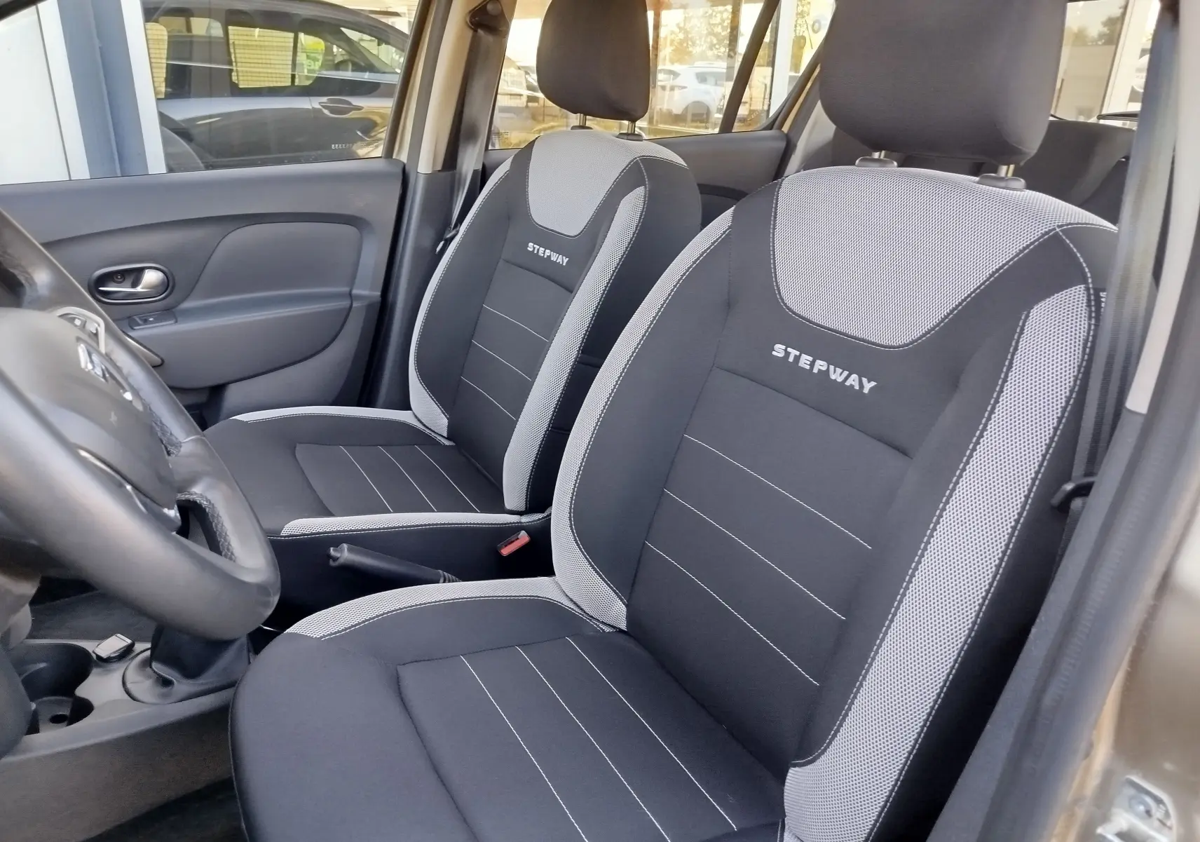 Intérieur de la Dacia Sandero Stepway 2020, vue côté gauche sur les sièges noirs et gris avec logo Stepway brodé.