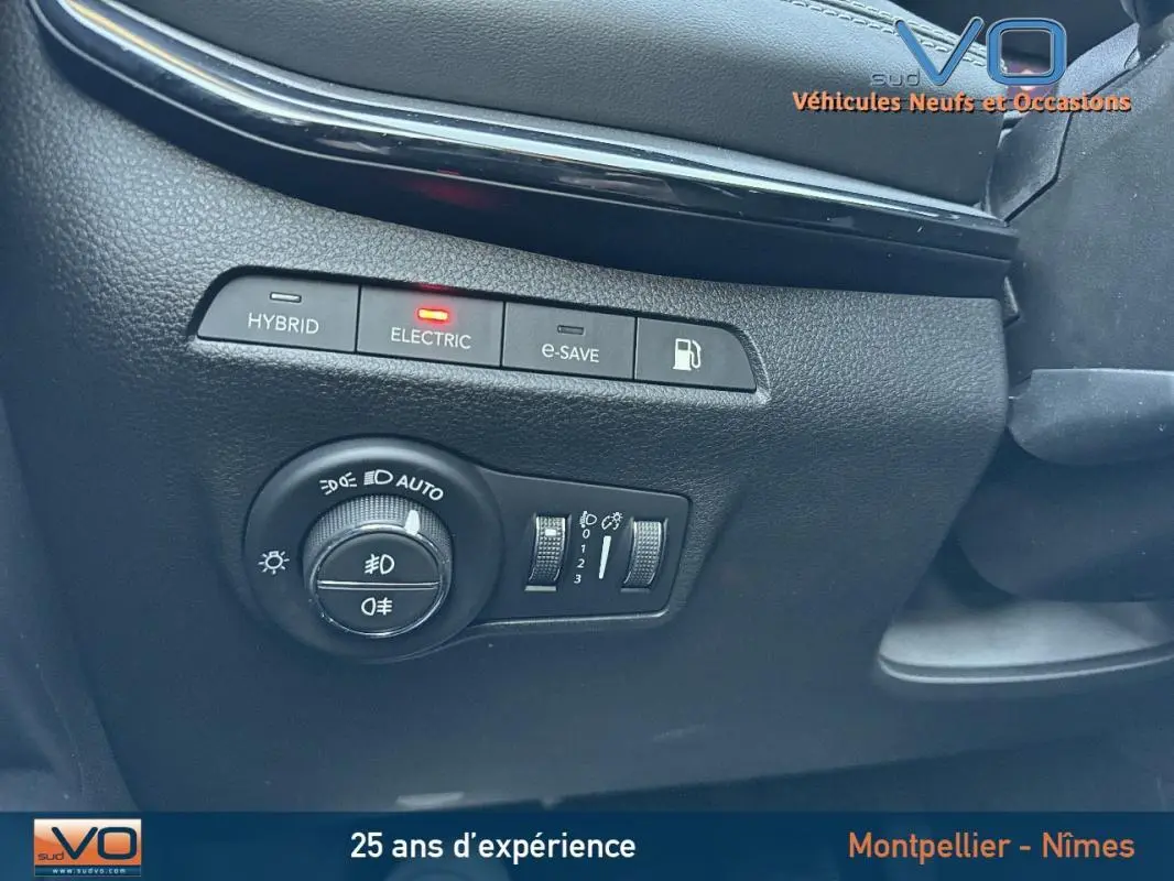 Vue rapprochée des commandes d'éclairage et mode électrique du Jeep Compass blanc 2023, intérieur noir.