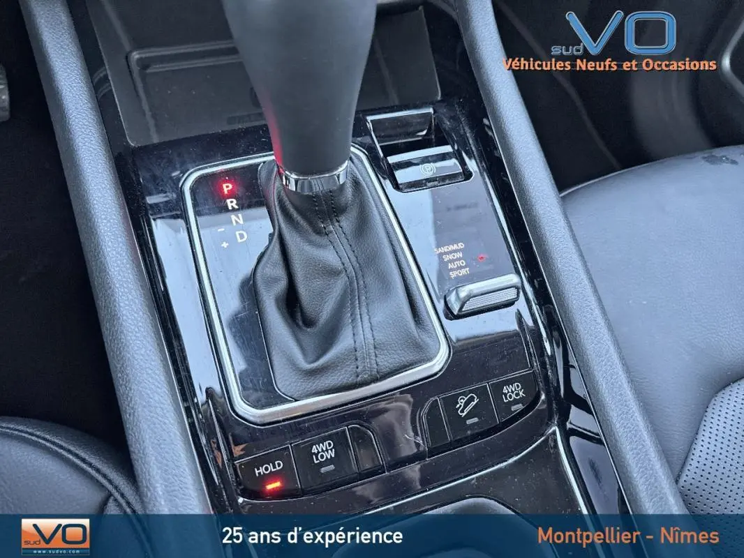 Gros plan sur la console centrale noire avec levier de vitesse automatique du Jeep Compass blanc 2023 hybride.