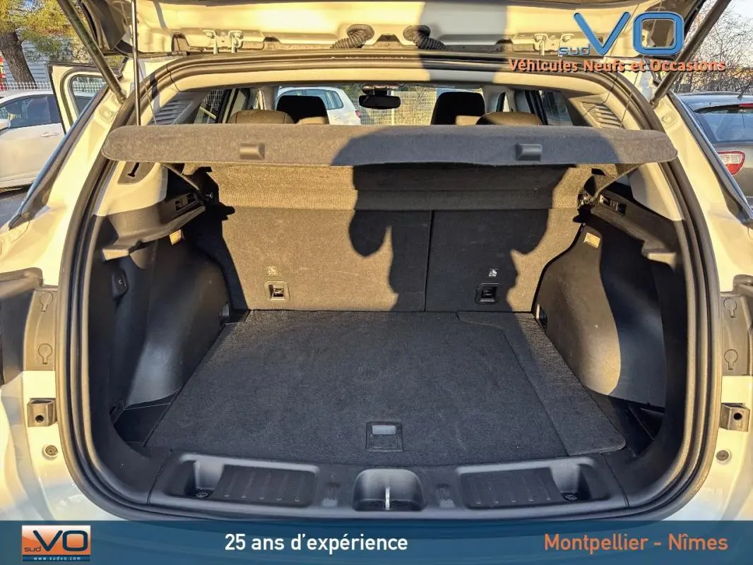 Coffre ouvert vu de l'arrière du Jeep Compass blanc 2023, montrant un espace de chargement propre et spacieux.