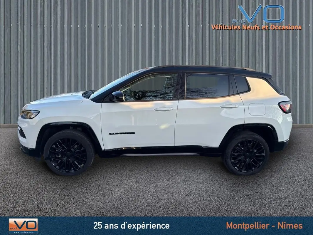 Jeep Compass blanc vue de profil côté gauche avec jantes alliage noires et toit noir contrasté.