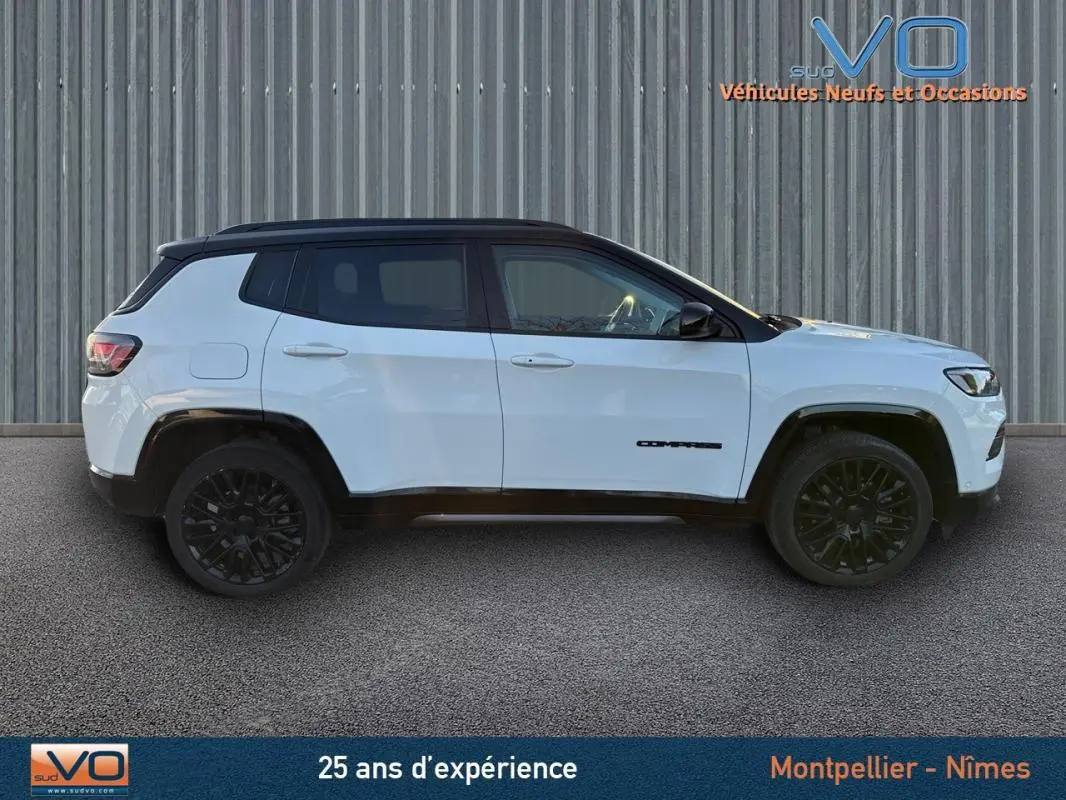 Jeep Compass blanc vu de profil côté gauche, avec toit noir et jantes alliage noires de 19 pouces.