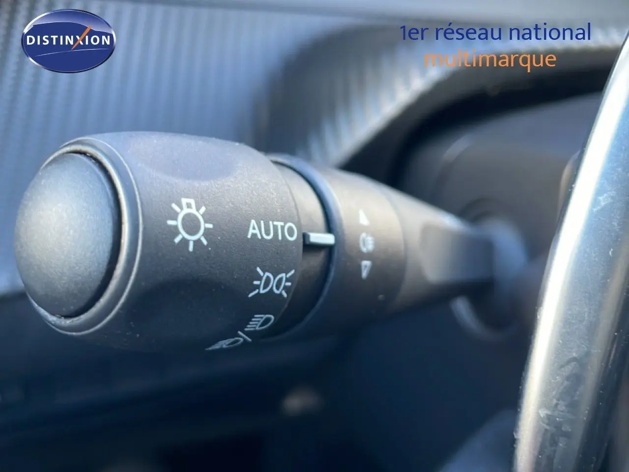 Gros plan sur la commande d’éclairage automatique dans l’habitacle d’une Peugeot 208 noire 2025.